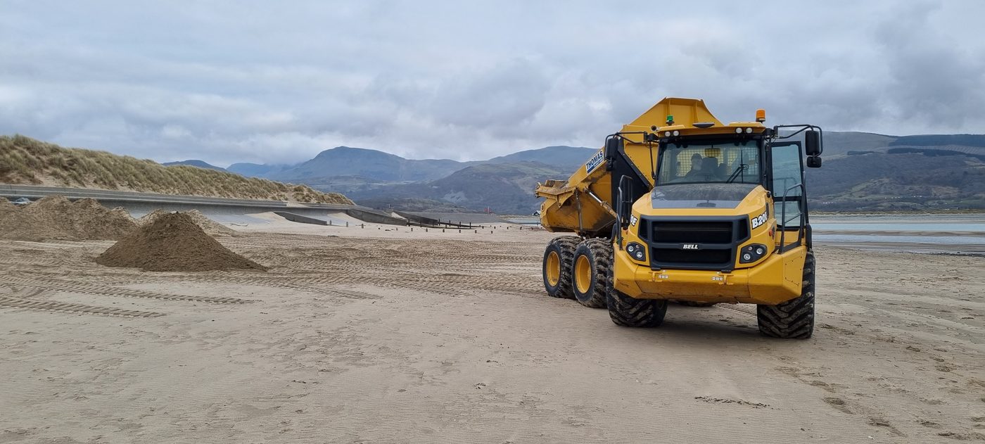 Articulated dumper moving sand on Barmouth Beach