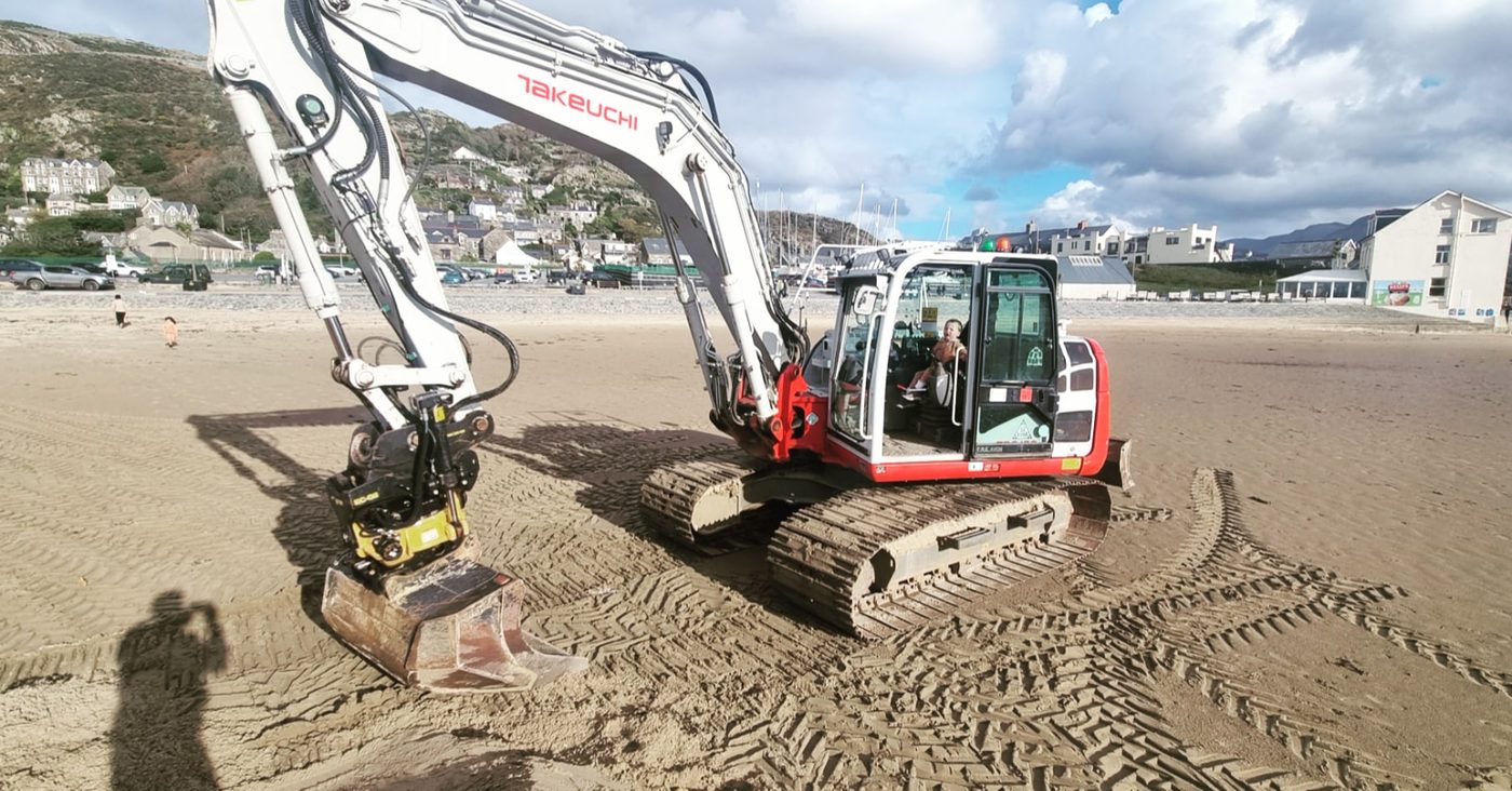 Excavator clearing sand on Barmouth seafront